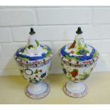 A pair of Italian pottery jar and covers, painted with flowers, 30cm high, (2)