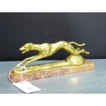 A brass figure of a racing greyhound on a hardstone base, 24cm long