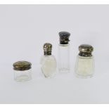 A group of three early 20th century silver topped glass bottles, each with glass stoppers intact