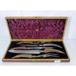 A five piece horn handled carving set with silver collars in a fitted case