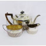An Edwardian silver half fluted teaset comprising teapot, sugar bowl and milk jug, with makers marks