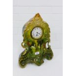 A pottery Rococo style mantle clock with swan and lake pattern, the enamel dial with Roman numerals,