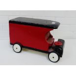 A vintage red and black painted wooden bus with plastic wheels, 43cm long
