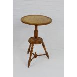 A two tier circular topped table, on turned tripod supports, 76 x 50cm