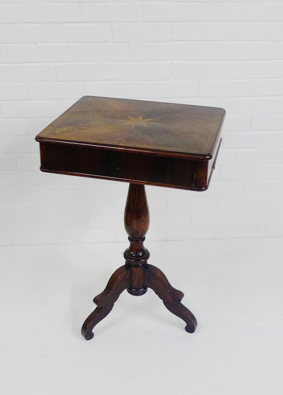 A Biedermeier rosewood and grain painted work table, with star motif to centre, raised on tripod