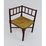 An Arts & Crafts bobbin turned corner chair with rush seat 65 x 62cm