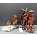 A group of three carved wood oriental figures together with a Japanese porcelain saucer in hand