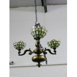 A bronze patinated ceiling light with three branches and Tiffany style glass shades