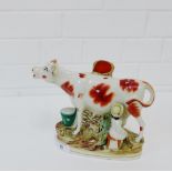 A 19th century Cow and Milk Maid spill vase on oval and gilt lined base, 20cm high