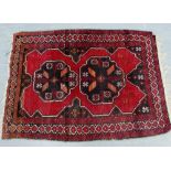 A Kazak type mat with red field and double flowerhead motifs to centre, 105 x 54cm