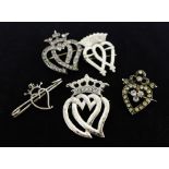 Luckenbooth brooches to include two Scottish silver, a paste set example and two white metal heart