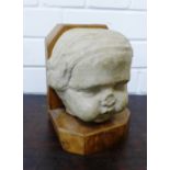 A stone ware head on oak base