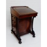 A 19th century mahogany davenport, the sloping top with leather skivver over an arrangement of