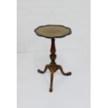 A mahogany wine table, the circular top with wavy edge, raised on tapering column and tripod