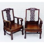 A pair of Chinese hardwood open armchairs, with stylised pierced splats over solid seats and