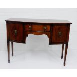 A mahogany sideboard with a central drawer flanked by cupboard doors, on square tapering supports