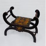 An ebonised Savonarola stool with classical motifs to seat and front, 60 x 74cm