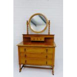 An Art Deco oak three dressing table with circular mirror on barley twist supports, over two short