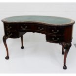 An Edwardian mahogany kidney shaped desk, the top with inset green leather skivver, over an