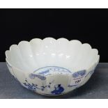 A Chinese blue and white bowl of lobbed circular form with a village scene to the interior with