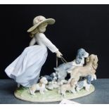 A Lladro porcelain figure of a girl with her dogs on an oval base, 23cm high