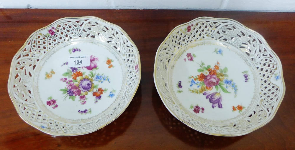 A pair of Dresden porcelain bowls with reticulated gilt lined rims and with floral sprays to centre,