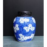 A Chinese blue and white prunus patterned jar with pierced ebonised hardwood cover, double