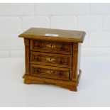 A miniature pine chest, the rectangular top with moulded edge over three panel drawers on a plinth
