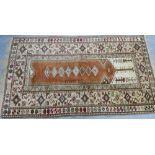 An eastern prayer rug, the central mihrab with row of eight diamond lozenges with multiple