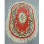 A Chinese oval rose pink rug, 152 x 98cm