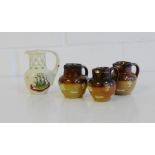 A group of three Doulton two-tone stoneware jugs, two with silver mounts, tallest 5cm, together with