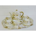 A Royal Crown Derby teaset, the white glazed porcelain with gilt rope twist handles and foliate