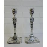 A pair of Edwardian silver candlesticks of neo-classical design, each with urn shaped tops above