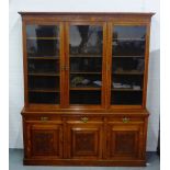 An early 20th century oak library bookcase, the cornice with dentil frieze over three glazed