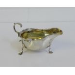 George V silver sauce boat with wavy rim and scroll handle, on pad feet, bearing makers mark for