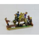 A Runnaford pottery figure group of five figures upon a donkey on a rectangular plaque, signed