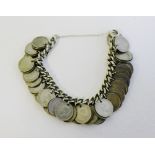 A silver bracelet hung with a quantity of George VI three pence coins