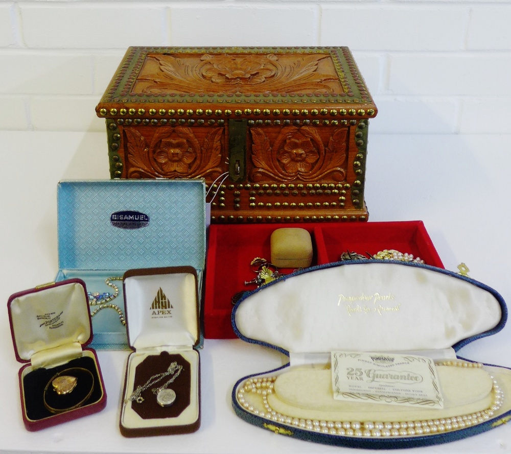 A carved wooden jewellery box containing a quantity of silver and costume jewellery to include