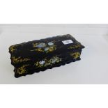 A black lacquered box, the hinged lid inlaid with abalone, 25 x 10cm