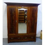 A mahogany and inlaid wardrobe, the dentil cornice over central mirror door, with two drawers to the