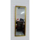 A rectangular gilt framed wall mirror, 85 x 34cm