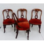 A set of four mahogany chairs with pierced splat backs and plush red seats, on turned tapering