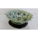 A Chinese celadon glazed bowl with a crimpled rim painted with insects flowers and foliage in