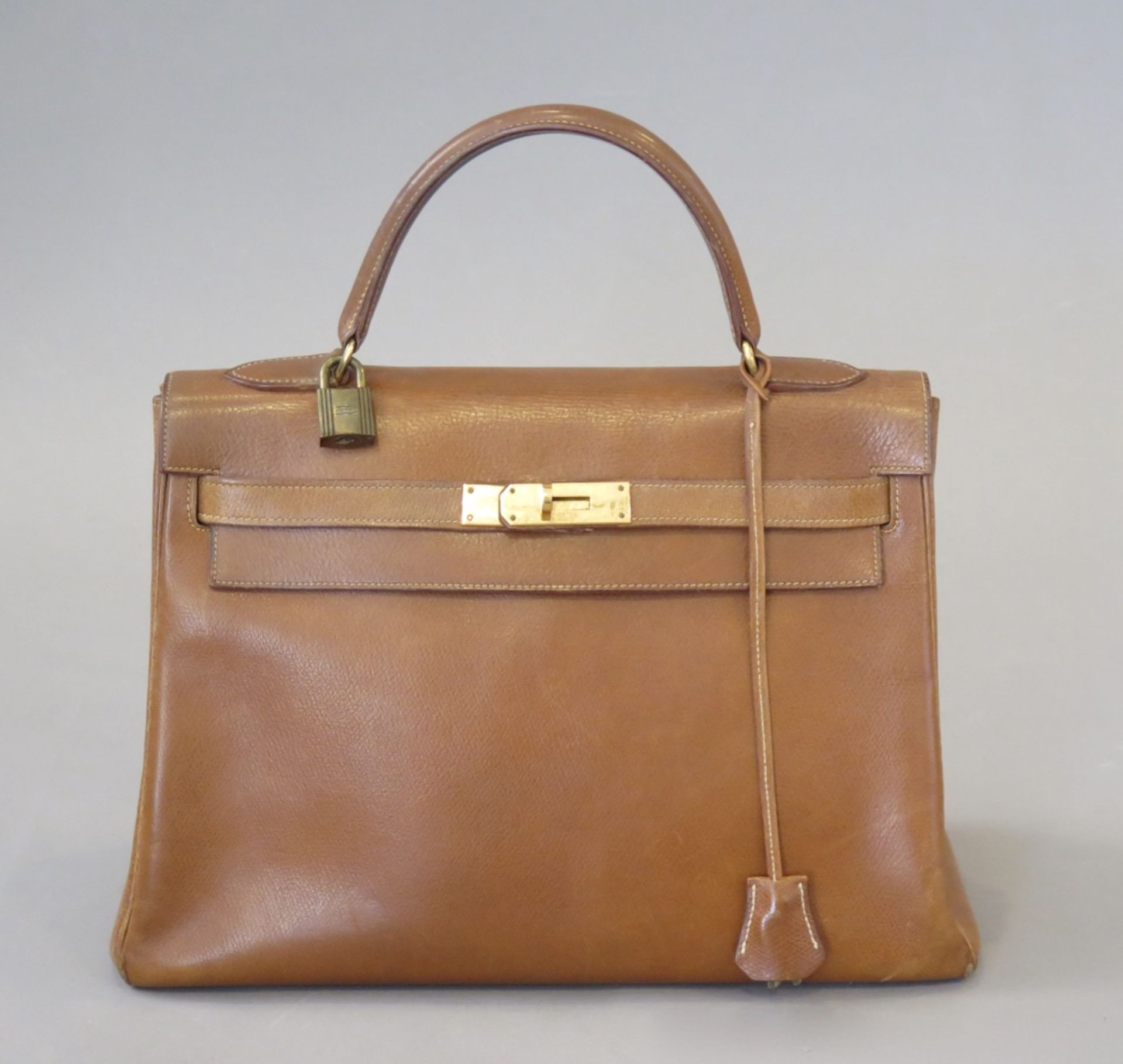 HERMES.Sac, modèle "Kelly" 32 cm, 1974.(haut. 22 cm, larg. 33 cm, prof. 13 cm). En cuir grainé gold,