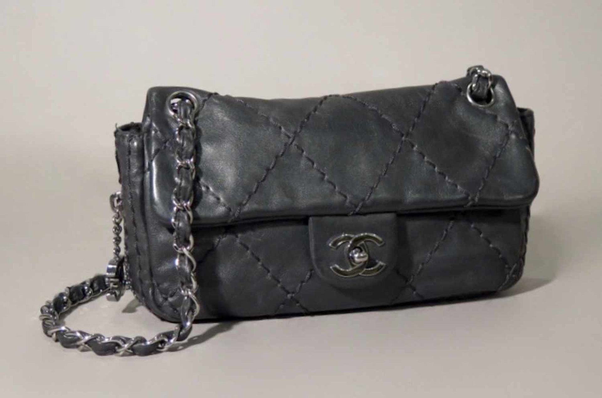 CHANEL.Sac, à l'esprit rock.(haut. 14 cm, larg. 25 cm, prof. 5.5 cm). En cuir lisse noir à grosses