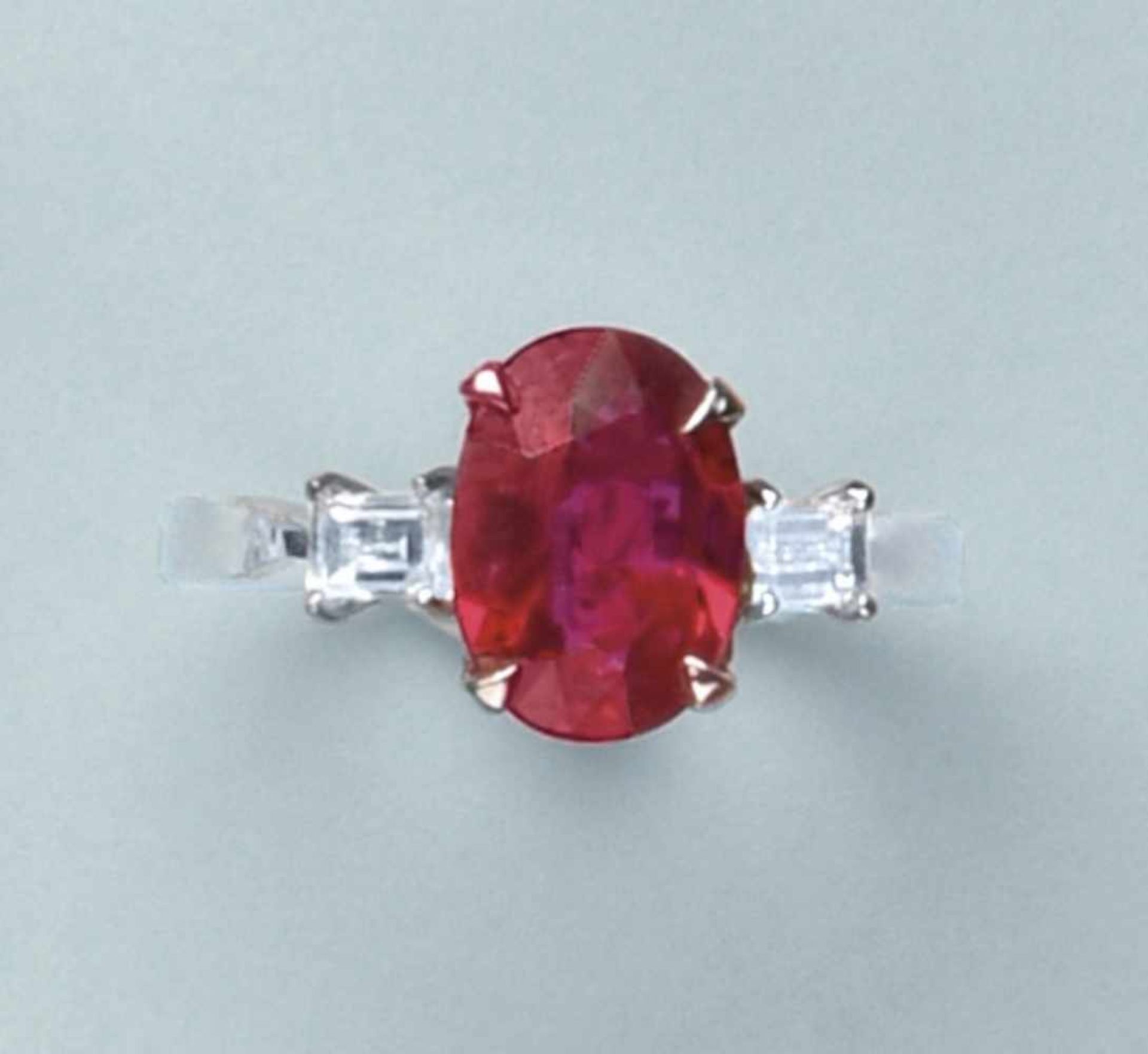 Bague en or blanc 750. Elle est ornée d'un rubis de taille ovale de 2.02 cts encadré par deux