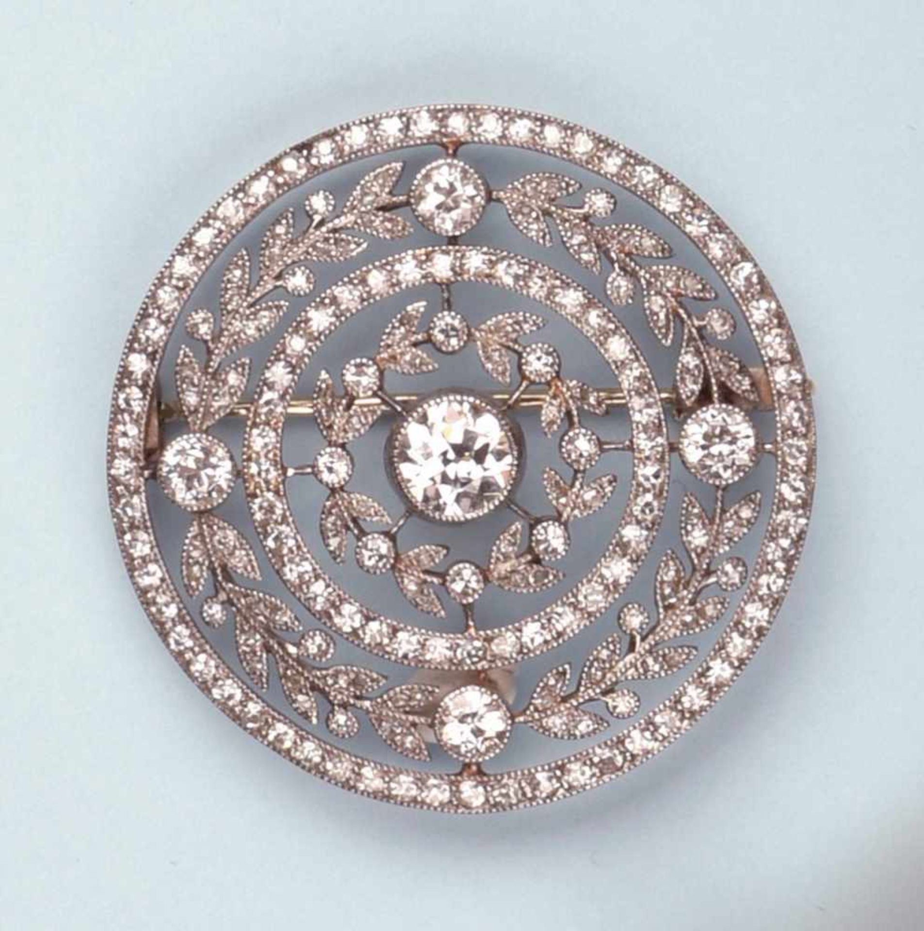 Ravissante broche en platine formant une rosace. Le décor ajouré à l'imitation de la dentelle est