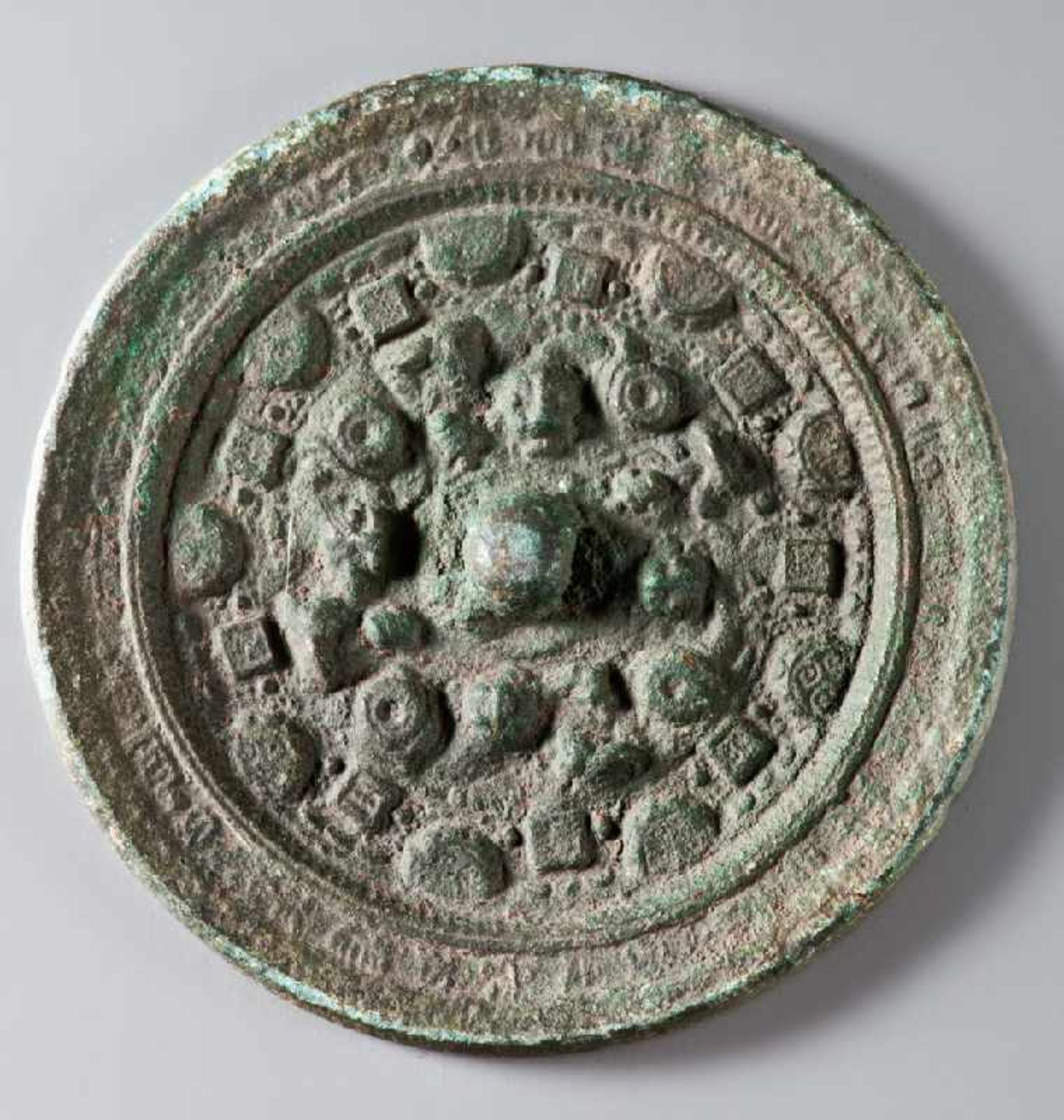 KLEINER SPIEGEL MIT MONSTERKÖPFENBronze. China, östliche Han-Dynastie, (25 – 220)Kreisrunde Form mit