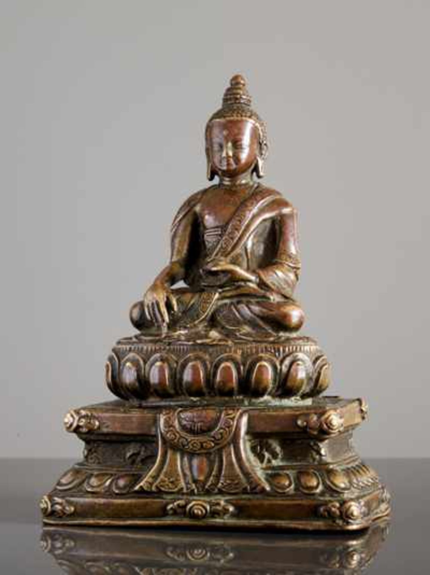 FRÜHE KLEINE BRONZE EINES AUF EINEM THRON SITZENDEN BUDDHA AKSHOBHYA Bronze, Tibet. ca. 16. Jh. Eine