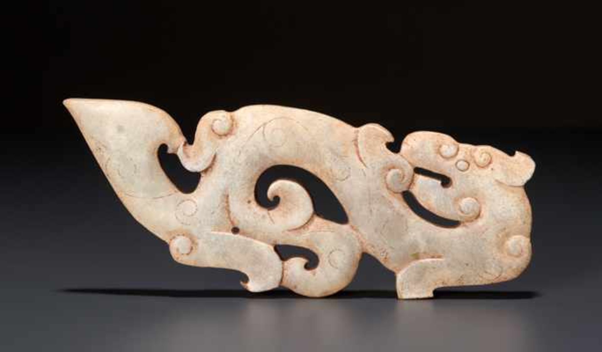 WEISSER KUILONG-DRACHE ALS AMULETT夔龍形玉雕護身符。中國，東周代，公元前5世紀。寬10.5厘米，厚約0.3厘米。維也納私人舊藏。Bezeichnend für